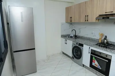 a kitchen with a refrigerator and a washing machine at Stylish & Cozy Apartment with Modern Design in Beni Mellal