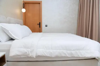 a large white bed in a bedroom with a window at Stylish & Cozy Apartment with Modern Design in Beni Mellal