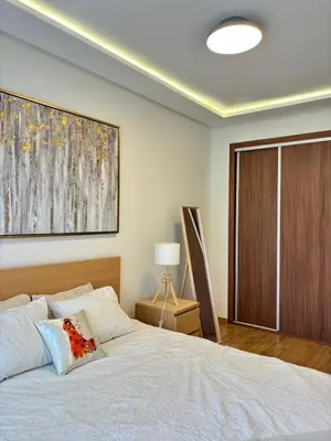 a bedroom with a bed and a large painting on the wall at Le murmure in Oulad Akkou