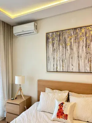 a bedroom with a bed and a painting on the wall at Le murmure in Oulad Akkou