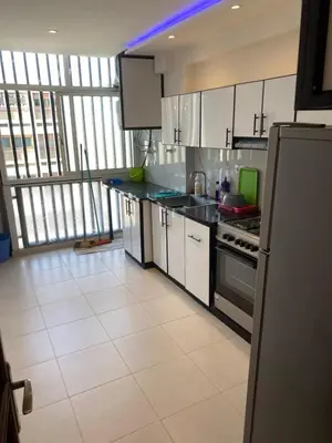 a kitchen with white appliances and a large window at Miloche home in Oulad Akkou
