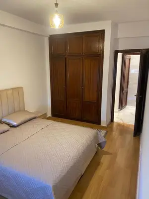 a bedroom with a bed and a wooden cabinet at Miloche home in Oulad Akkou