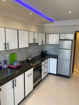a kitchen with white cabinets and stainless steel appliances at Miloche home in Oulad Akkou