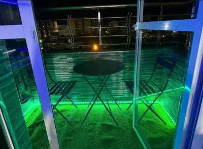 a table and chairs in a room with green lights at Appartement in Meknès