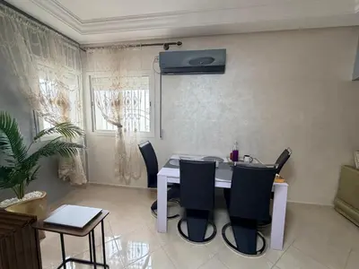 a dining room with a white table and chairs at Appartement in Meknès