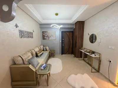 a living room with a couch and a table at Appartement in Meknès