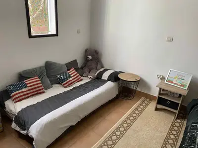 a bedroom with a bed with a teddy bear on it at Chambre dans un magnifique petit riad avec piscine in Aghmat