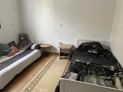 a bedroom with two beds and a teddy bear at Chambre dans un magnifique petit riad avec piscine in Aghmat