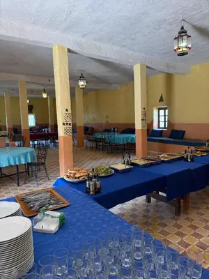 a room with two blue tables with plates of food at Auberge el oasis mharech in Foum Mharech