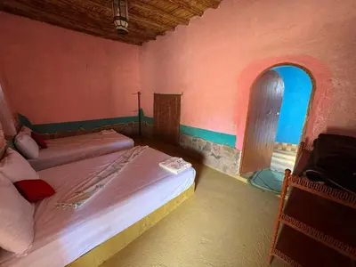 a bedroom with two beds and an open window at Auberge el oasis mharech in Foum Mharech
