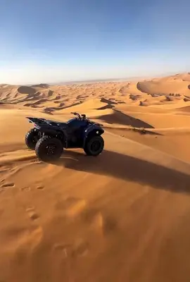 a atv driving through the sand in the desert at Merzouga desert camp in Merzouga