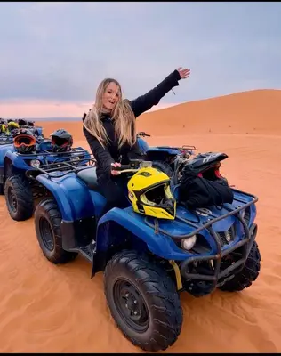 a woman sitting on a four wheeler in the desert at Merzouga desert camp in Merzouga