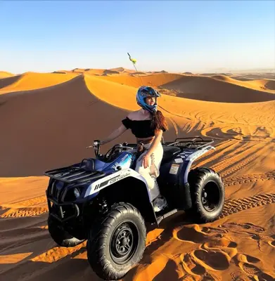 a woman riding a quad bike in the desert at Merzouga luxury tente in Merzouga