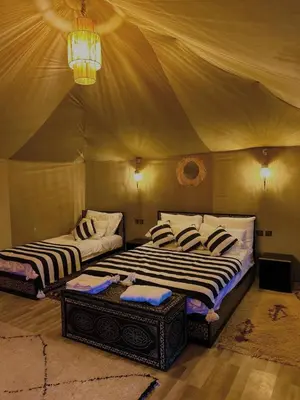 two beds in a room with a tent at Merzouga luxury tente in Merzouga