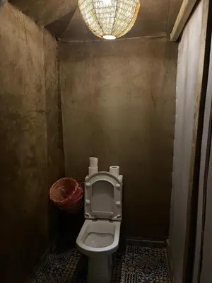 a bathroom with a toilet and a chandelier at Merzouga luxury tente in Merzouga