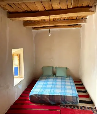 a bed in a small room with a window at GÎTE D'ETAPE Tighanimin Tarhalt