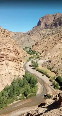 a winding road in a canyon in the desert at GÎTE D'ETAPE Tighanimin Tarhalt