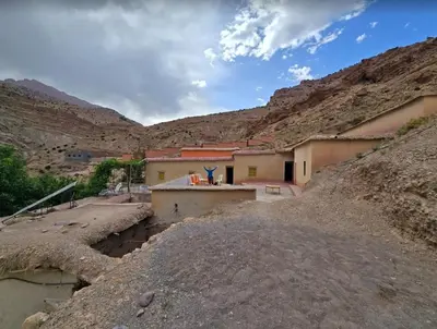 a building in the middle of a desert with mountains at GÎTE D'ETAPE Tighanimin Tarhalt