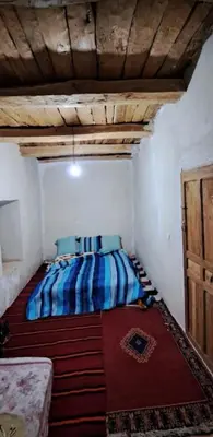 a bedroom with a bed in a room with a wooden ceiling at GÎTE D'ETAPE Tighanimin Tarhalt