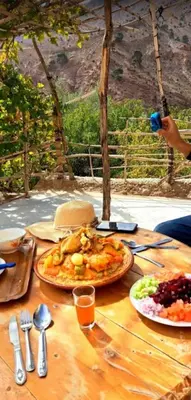 a wooden table with plates of food on it at GÎTE D'ETAPE Tighanimin Tarhalt