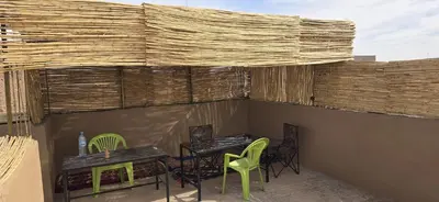 a patio with two tables and chairs on a roof at Desert feet in Mhamid