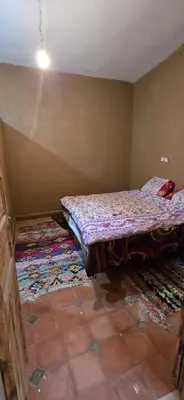 a bed in a room with a rug on the floor at Desert feet in Mhamid
