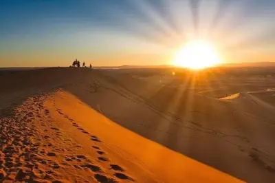 a group of people standing on top of a sand dune at Your Berber House in Merzouga