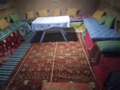 a room with chairs and a table and a rug at Bivouac Porte du Désert in Mhamid