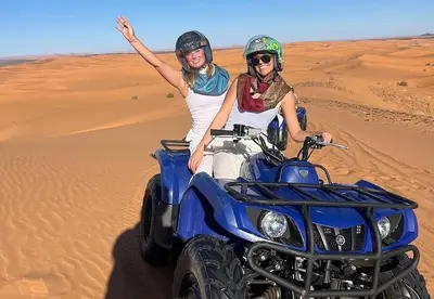 two women on a quad bike in the desert at Bein Merzouga Camp in Merzouga