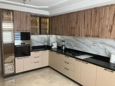 a kitchen with white cabinets and black counter tops at Baie D'AGADIR in Oulad Akkou