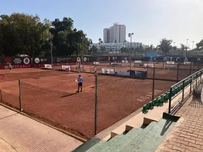 a person is standing on a tennis court at Baie D'AGADIR in Oulad Akkou