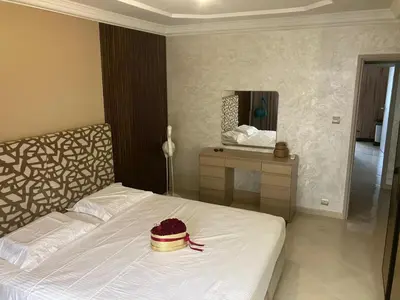a bedroom with a white bed and a mirror at Baie D'AGADIR in Oulad Akkou