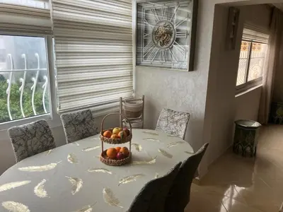 a dining room table with a basket of fruit on it at Baie D'AGADIR in Oulad Akkou