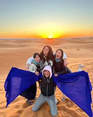 a group of girls posing for a picture in the desert at Merzouga Unique Standard Camp in Merzouga