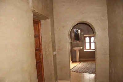 a hallway with a bathroom with a sink and a mirror at Sahara Apartament in Rissani