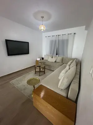 a living room with a couch and a flat screen tv at Exclusive Apartment for a Perfect Getaway in Fès