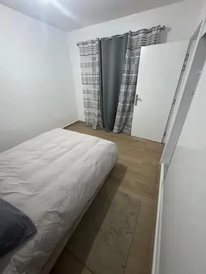 a bedroom with a bed and a door with curtains at Exclusive Apartment for a Perfect Getaway in Fès