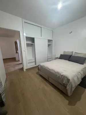 a bedroom with a bed in a white room at Exclusive Apartment for a Perfect Getaway in Fès