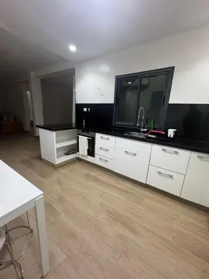 a living room with a television and white cabinets at Exclusive Apartment for a Perfect Getaway in Fès