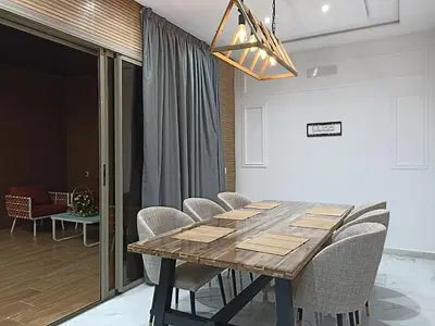 a dining room with a wooden table and chairs at Villa de luxe avec jardin et parking privé in Beni Mellal