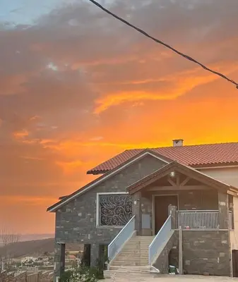 a house with a sunset in the background at Family Villa with Panoramic View of Infinite Horizon in Ifrane