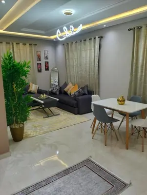 a living room with a table and a couch at well-equipped 2 bedroom apartment living room in Tiflet