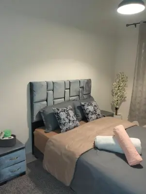 a bedroom with a large bed with a large headboard at well-equipped 2 bedroom apartment living room in Tiflet