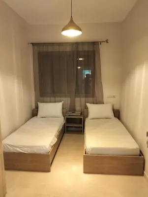 two beds in a small room with a window at well-equipped 2 bedroom apartment living room in Tiflet