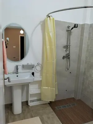 a bathroom with a sink and a shower with a mirror at well-equipped 2 bedroom apartment living room in Tiflet