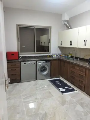 a kitchen with a washer and dryer in a room at well-equipped 2 bedroom apartment living room in Tiflet