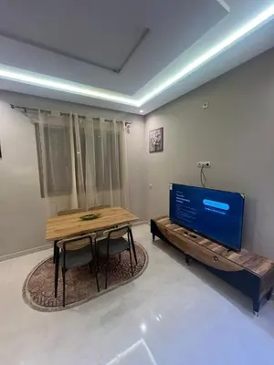 a living room with a table and a television at NEW Luxury & Equipped Dalia , 2 bedrooms living room in Tiflet