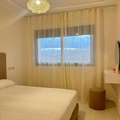 a bedroom with a bed and a window at Warm & Stylish Boho Condo - 6 km to Old Medina in Fès