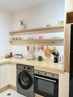 a kitchen with a washing machine and shelves at Warm & Stylish Boho Condo - 6 km to Old Medina in Fès