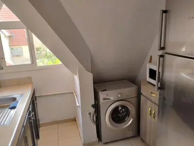 a small kitchen with a washer and a refrigerator at Dar Yasmine 3 in Ifrane